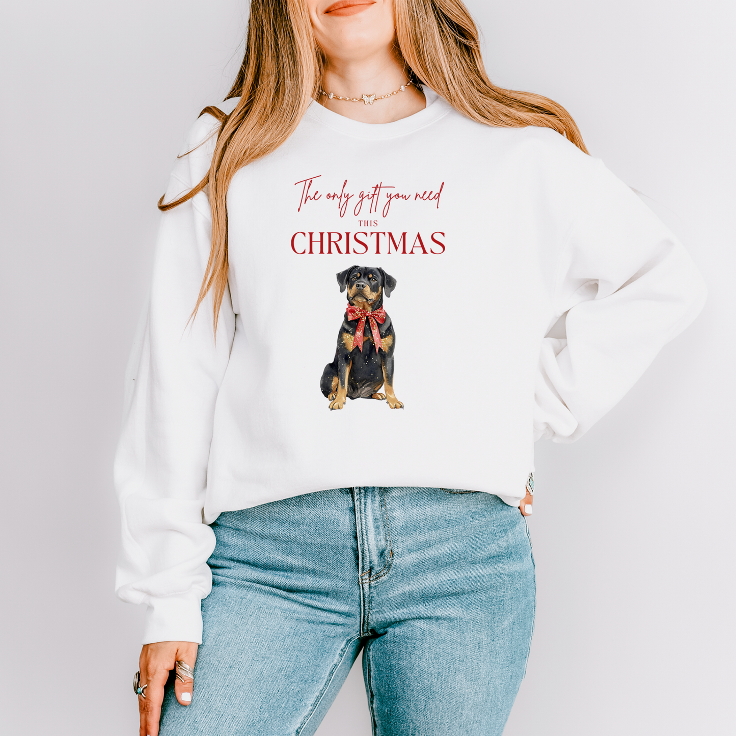 Person wearing a white sweatshirt with a dog graphic and text on a plain background
