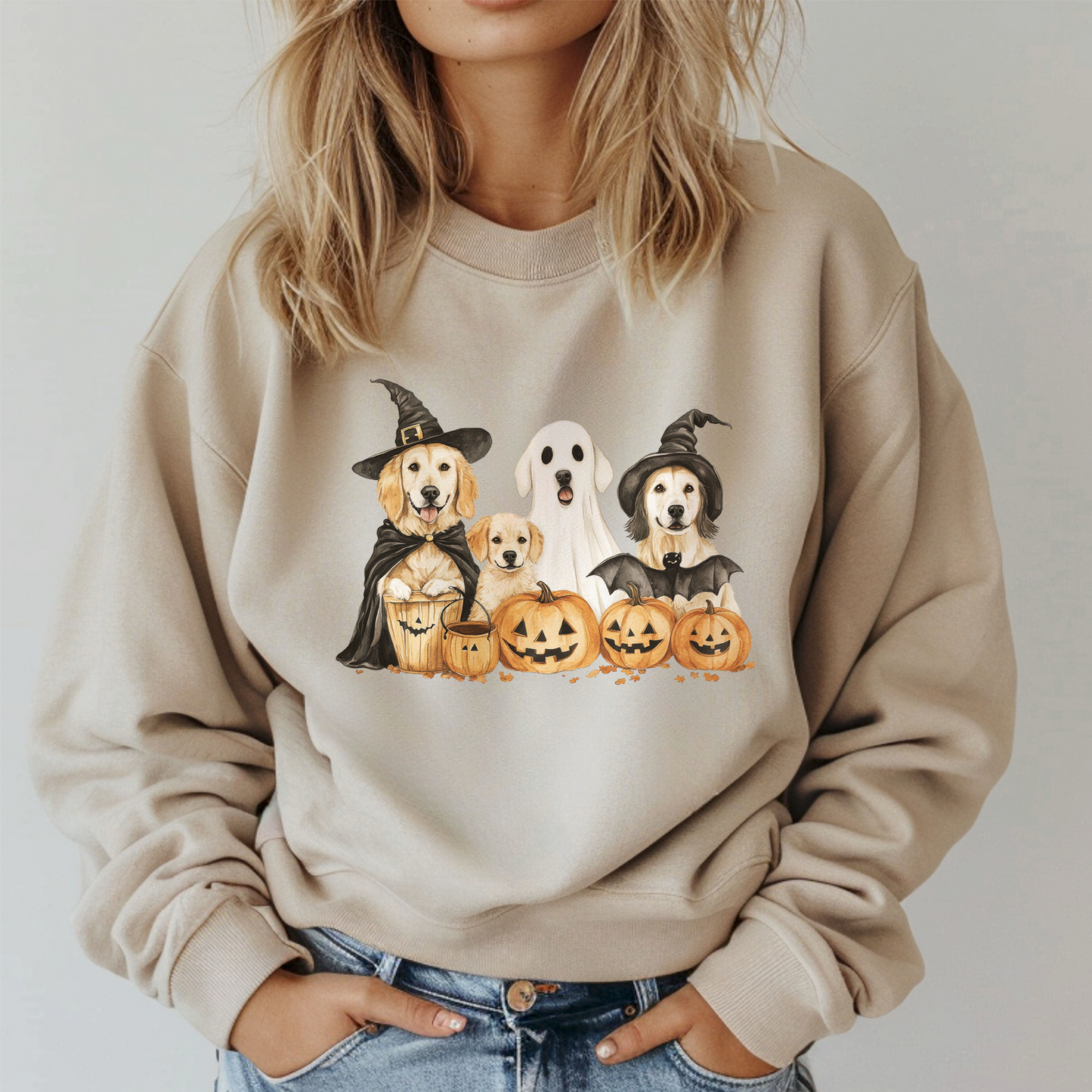 Beige sweatshirt with Halloween-themed design of dogs and pumpkins worn by a person.