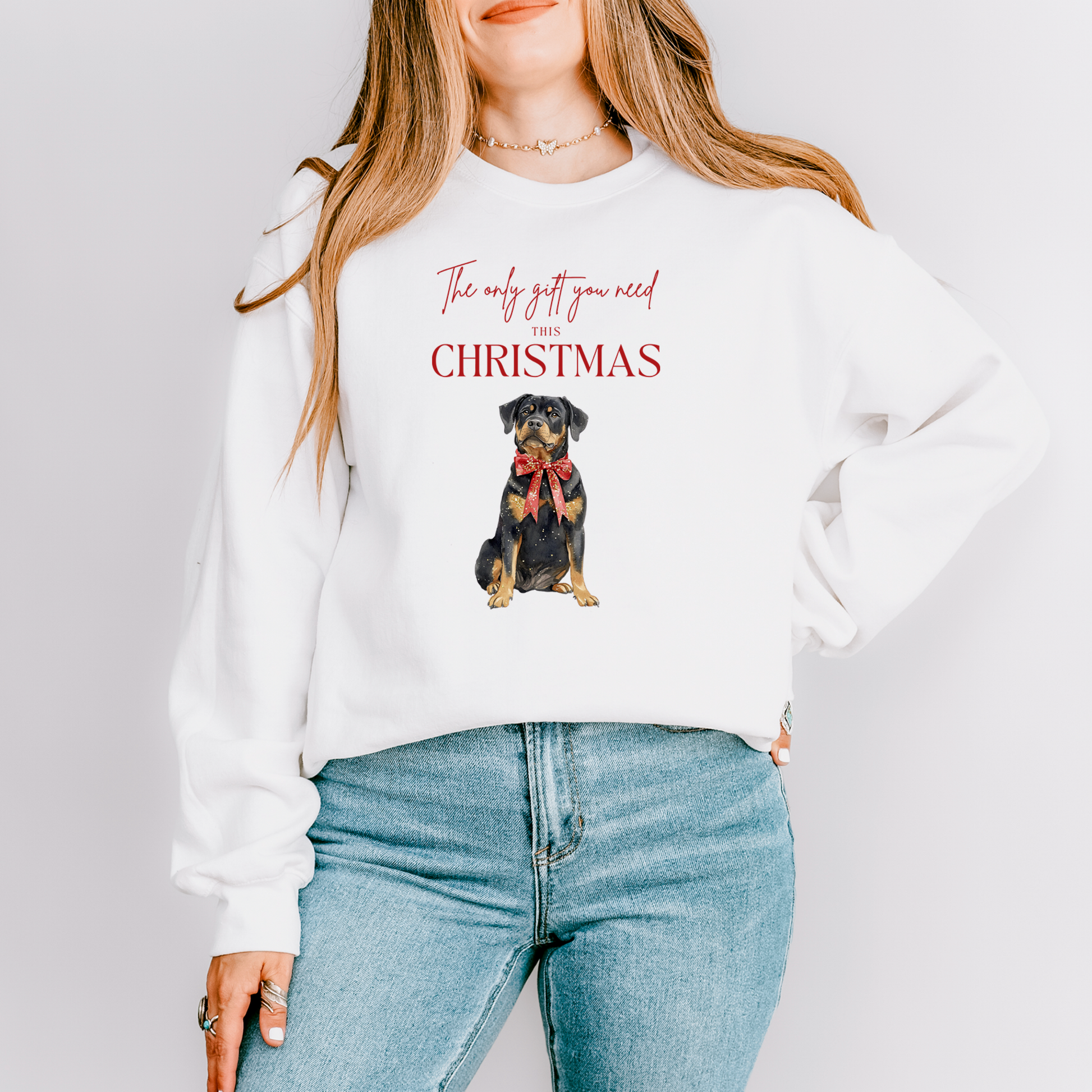 Person wearing a white sweatshirt with a dog graphic and text on a plain background