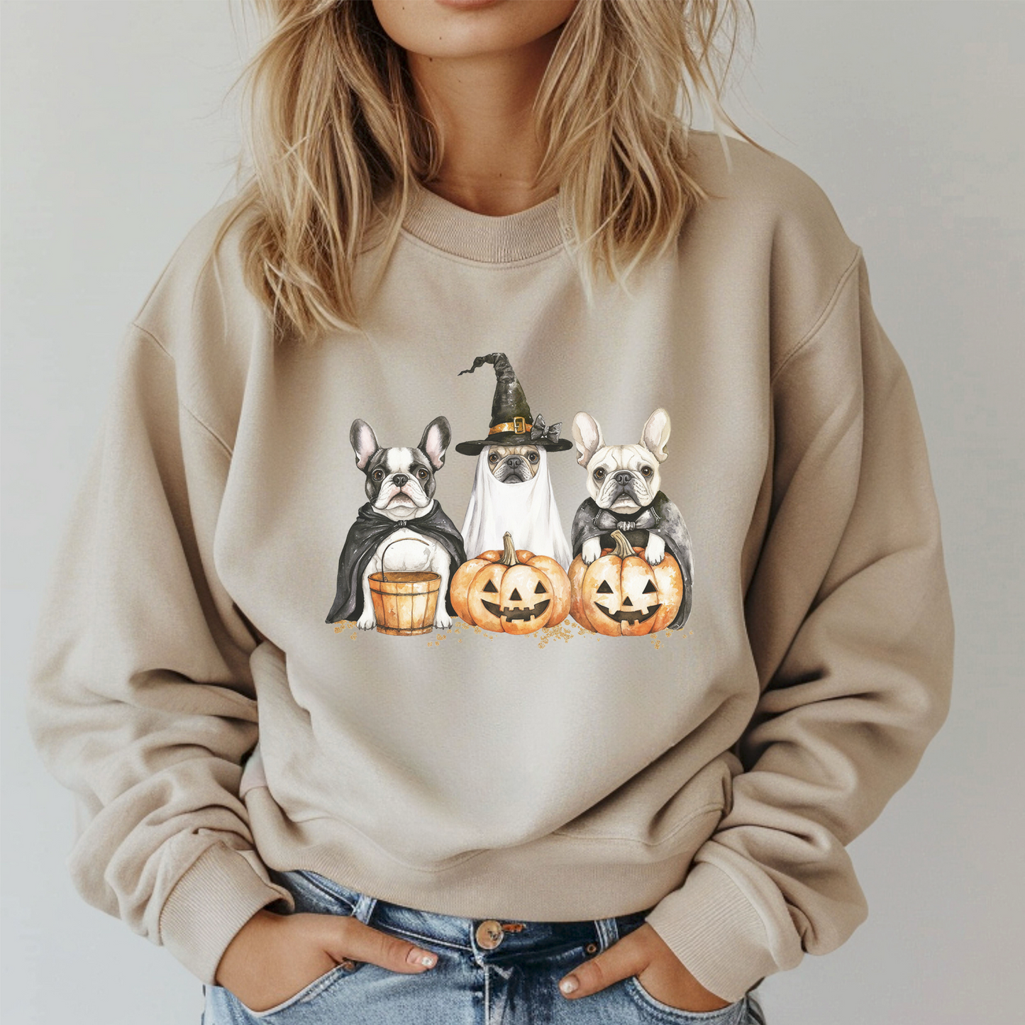 Beige sweatshirt with Halloween-themed design of dogs and pumpkins worn by a person.