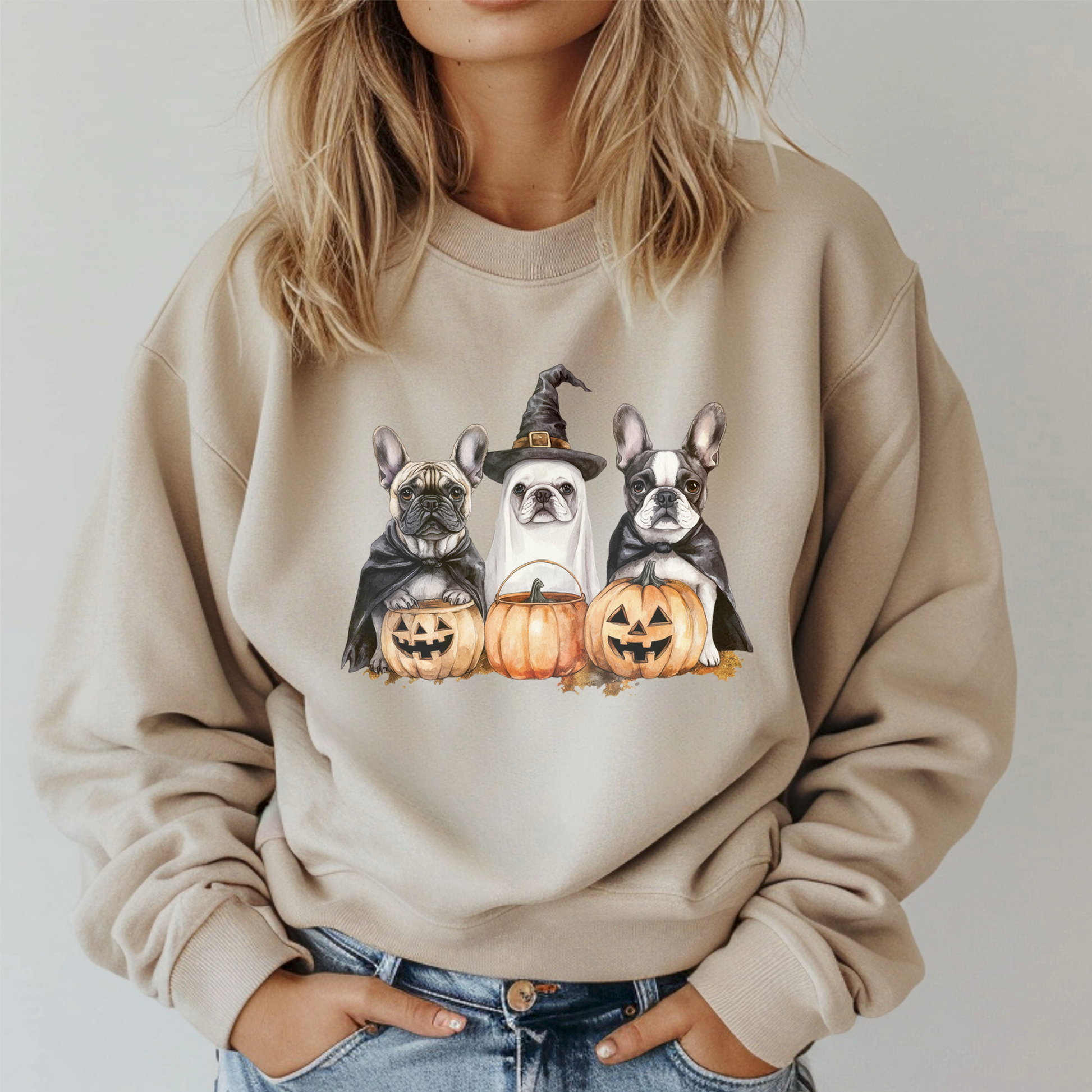 Beige sweatshirt with Halloween-themed design of dogs and pumpkins worn by a person.
